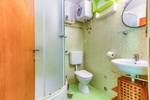 A bathroom with a toilet, sink, and mirror. - Apartments Filipovic with garden (Split)