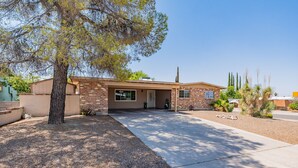 A single-story house with a brick exterior, a front porch, and a driveway leading to the entrance. - Charming 4-bedroom house, family and pet friendly, in desirable east Tucson! (Tucson)