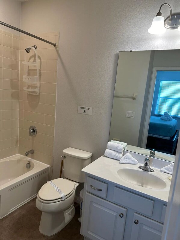 A bathroom with a bathtub, toilet, and sink.
