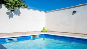 A swimming pool with clear blue water, surrounded by white walls. - Beautiful apartment in Galizana (Galizana)