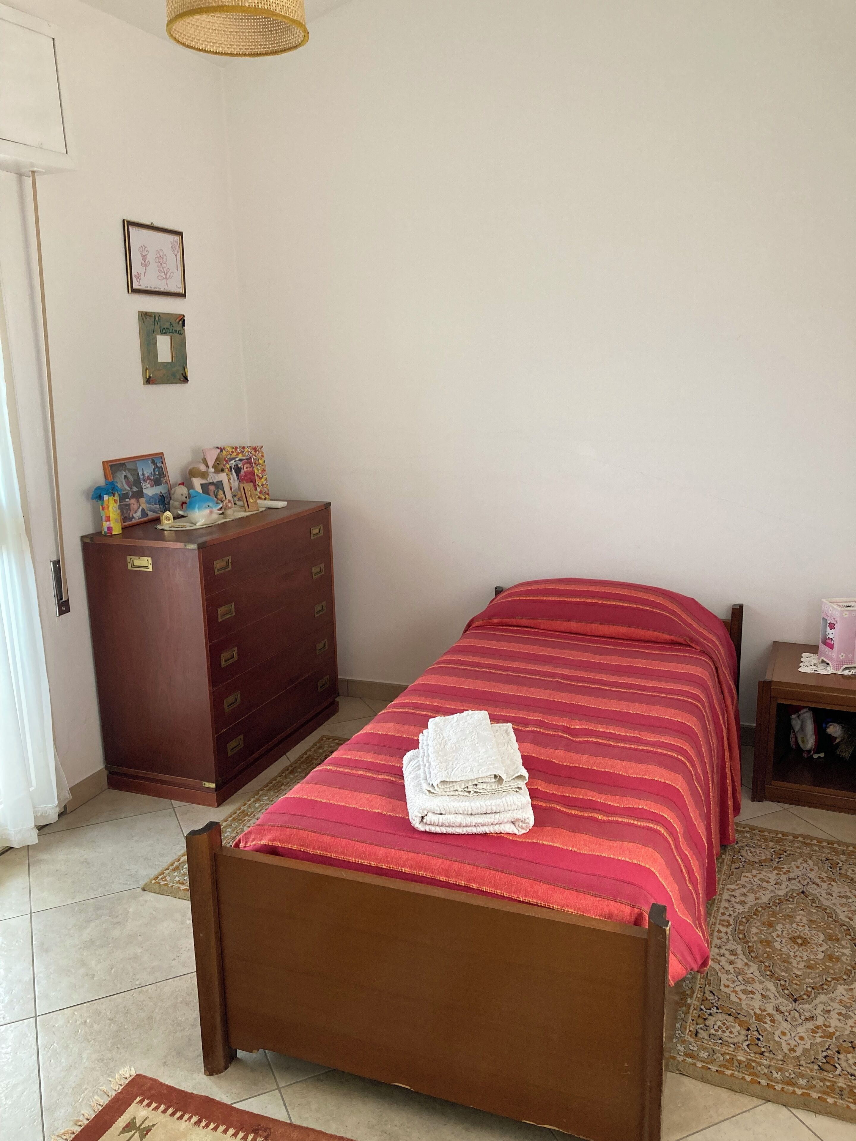 Ein Schlafzimmer mit einem hölzernen Bett, einem Schminktisch und einem kleinen Nachttisch.