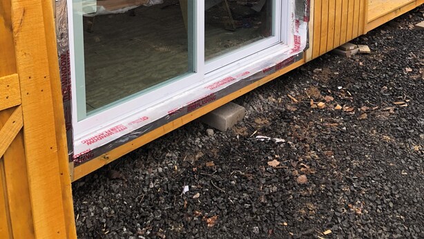A wooden building with a large sliding glass door, a metal roof, and a gravel ground. - Chateau Tina in the Mountains AC, Dog Friendly East Durham N (East Durham)