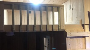 A wooden interior with a kitchen area, a door, and a window. - Chateau Tina in the Mountains AC, Dog Friendly East Durham N (East Durham)