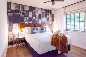 Un lit bien fait, avec une couverture marron, une tête de lit en bois et plusieurs oreillers.