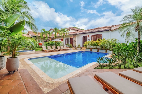 Een buitenzwembad, parasols voor strand/zwembad