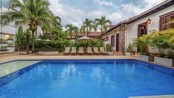 Een buitenzwembad, parasols voor strand/zwembad