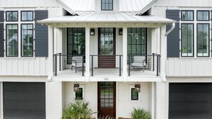 A two-story house with a front porch, a garage, and a large window. - Tucked among the treetops and steps to walking trail (Bluffton)