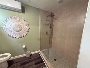 Een douche, handdoeken, zeep, toiletpapier