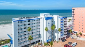 A hotel with multiple floors, a pool, and a beach view.