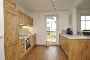 Eine moderne Küche mit Holzausstattung, einem eingebauten Backofen und einer Spüle.