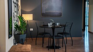 Un comedor moderno con una mesa redonda, sillas negras y una planta en maceta.