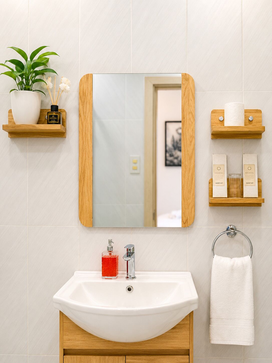 A bathroom with a white sink, a mirror, a towel rack, and wooden shelves with toiletries.