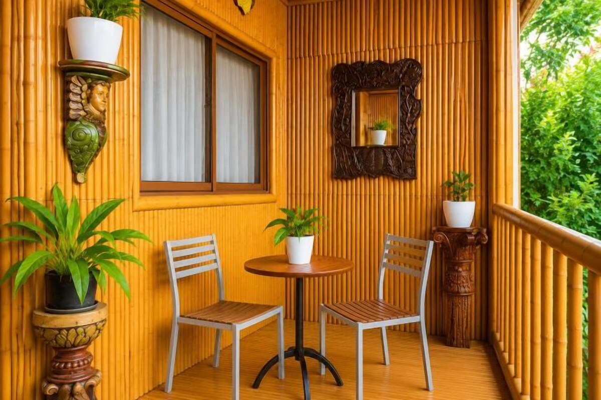 A wooden balcony with two chairs, a table, and potted plants.