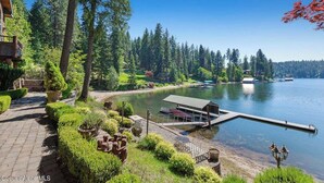A lakeside property with a dock, a covered seating area, and a pathway leading to a building. - Chateau Lac Hayden-Lake Front Luxury w/ Boats & Polaris rentals, lots of toys (Hayden)