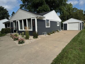 A residential house with a garage, a driveway, and a landscaped garden.