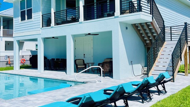 Ein zweistöckiges Haus mit Pool, Außenbereich und einer Treppe.