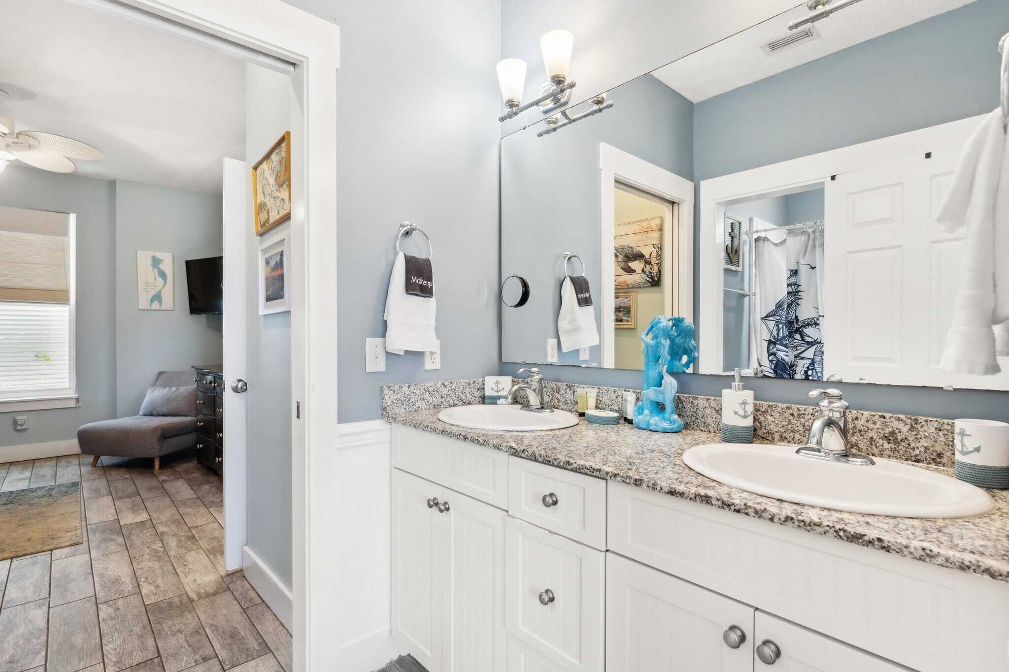 A bathroom with two sinks, a large mirror, and a towel rack.