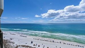 A beach with rows of sun loungers and a lifeguard tower. - Gull Watch by Avantstay Beachfront Condo (Panama City Beach)