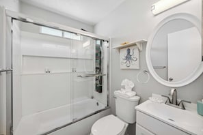 A modern bathroom with a glass-enclosed shower, a white toilet, a sink with a mirror, and a towel rack. - Aqua Horizon by Avantstay Pool, Near the Beach (Panama City Beach)