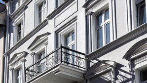 A multi-story building with a classical architectural style, featuring symmetrical windows and ornate balcony railings. - 2HomeRent Estrella 10 | Old Town | Spacious (Torun)