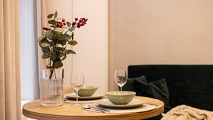 Ein Esstisch mit einer Vase voller roter Beeren, zwei Gläsern und einer Schüssel.