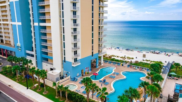 A high-rise hotel with a pool area, beach access, and a view of the ocean. - Shoreline Serenity by Avantstay Beachfront + Views! (Panama City Beach)