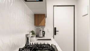 Eine moderne Küche mit Gasherd, Spüle und Schrank.