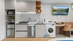 A modern kitchen with built-in appliances, a dining area with a wooden table and chair, and a large window with a mountain view.