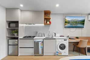 Prepare meals in a fully equipped kitchen with a dishwasher, refrigerator, and washing machine.