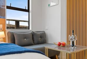 Relax in this stylish room with a sofa by the window, offering a view of the city and a bridge.