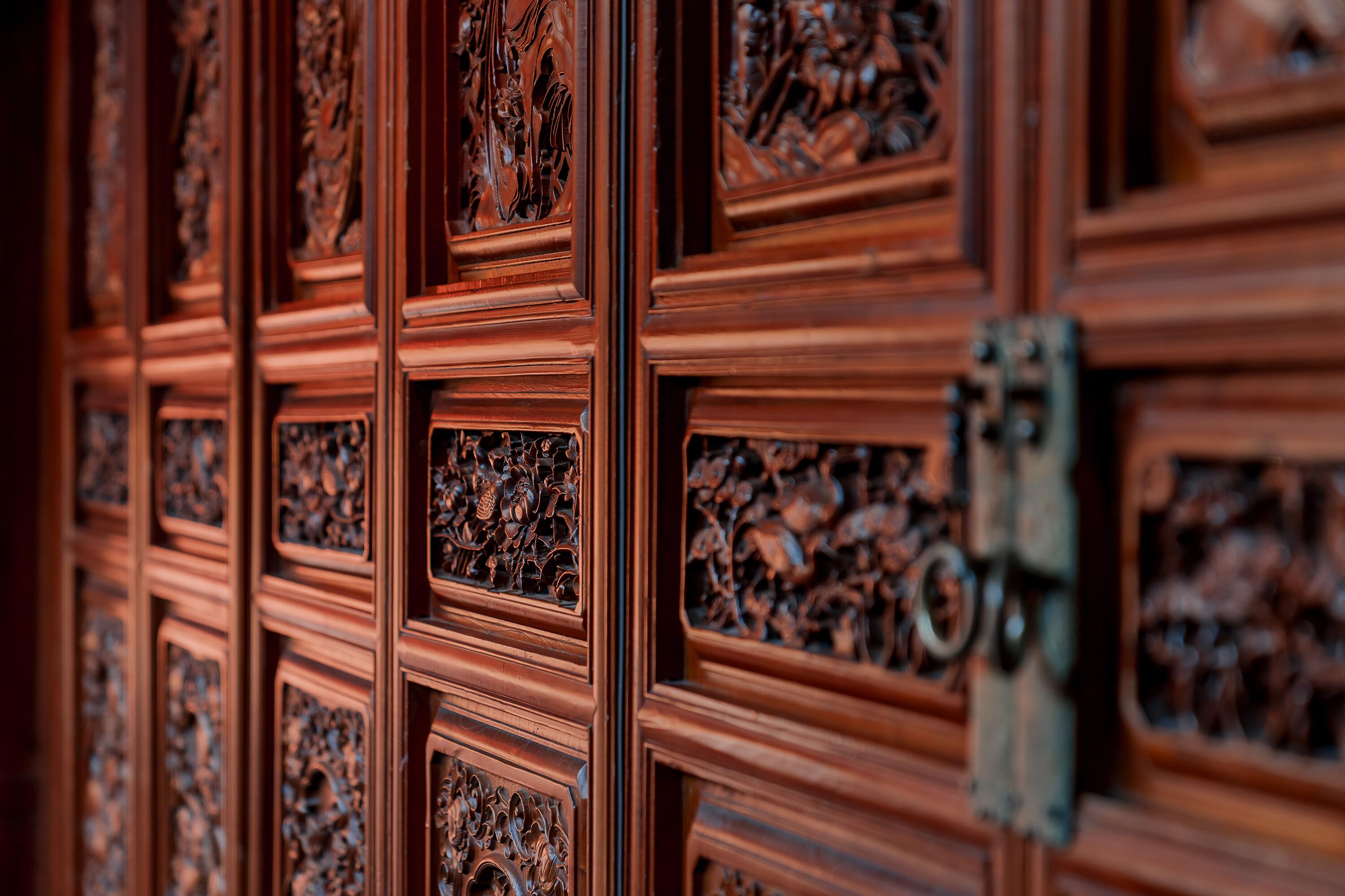 A wooden panel with intricate carvings, likely part of a building's interior.