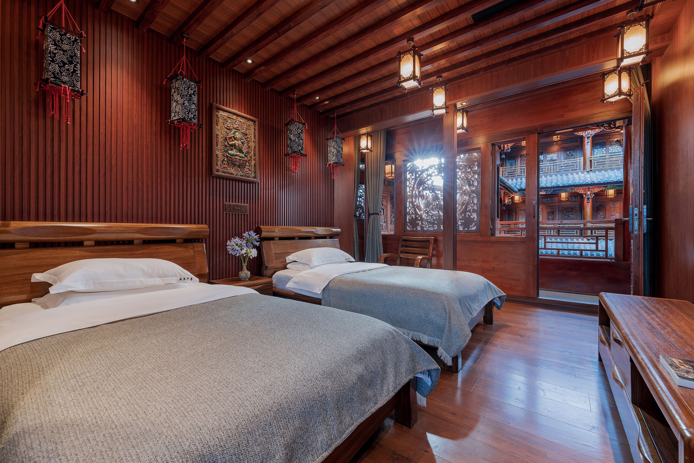 Habitación de hotel con dos camas, paredes de madera y decoración tradicional.