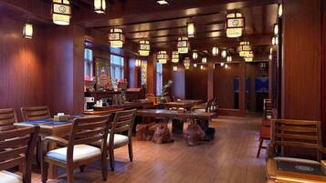 A restaurant with wooden furniture, hanging lanterns, and a traditional decor.