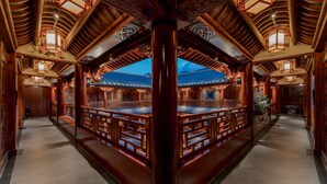 A traditional wooden building with a central courtyard, ornate wooden railings, and lanterns. - Spirited Silky Inn (Dali)