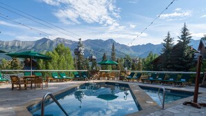 Poolbereich mit Liegestühlen und Bergblick.