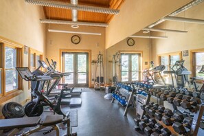 A gym with treadmills, weight benches, and kettlebells.