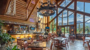 Un restaurant spacieux, doté d’un décor intérieur en bois, de grandes fenêtres et d’un espace bar.