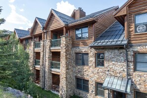 Ein mehrstöckiges Blockhaus mit Steinverzierungen, Balkonen und einem Metallvorsprung.