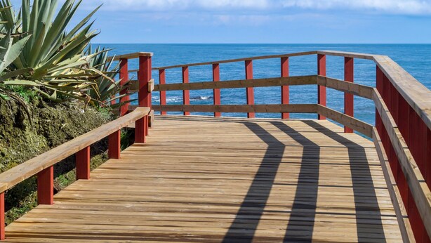 A wooden boardwalk with red railings leading to the ocean. - Los Lagos de Santa Maria by Interhome (Elviria, Marbella)