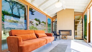 Ein modernes Wohnzimmer mit einem großen orangefarbenen Sofa, einem kleinen Tisch und einem Fernseher.