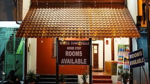 A building with a tiled roof and a sign indicating rooms are available. - White Town Villa  (Puducherry)