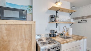 A compact kitchen with a microwave, coffee maker, and stove. - Sun-kissed by Avantstay Beachfront Access (Panama City Beach)