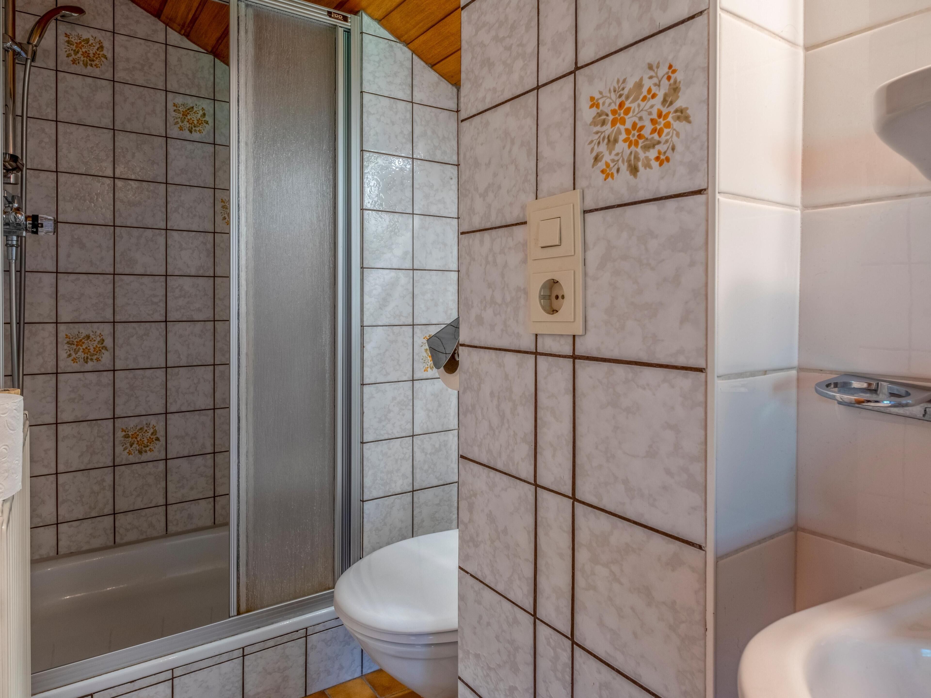Ein Badezimmer mit Dusche, Toilette und Waschbecken.