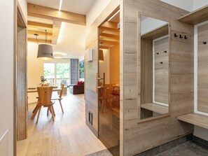 Um interior moderno com piso de madeira, área de refeições com mesa e cadeiras, e sala de estar com sofá e lareira.