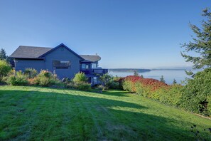 Ett hus med en terrass som vetter mot en sjö eller ett annat vattendrag.