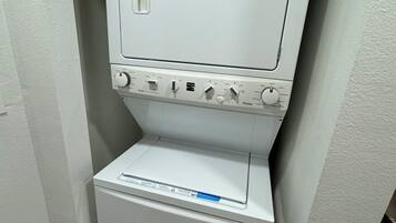 A compact, white, wall-mounted washer and dryer unit with a control panel featuring multiple settings.