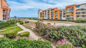 A hotel with multiple floors, outdoor pathways, and a view of the sea.
