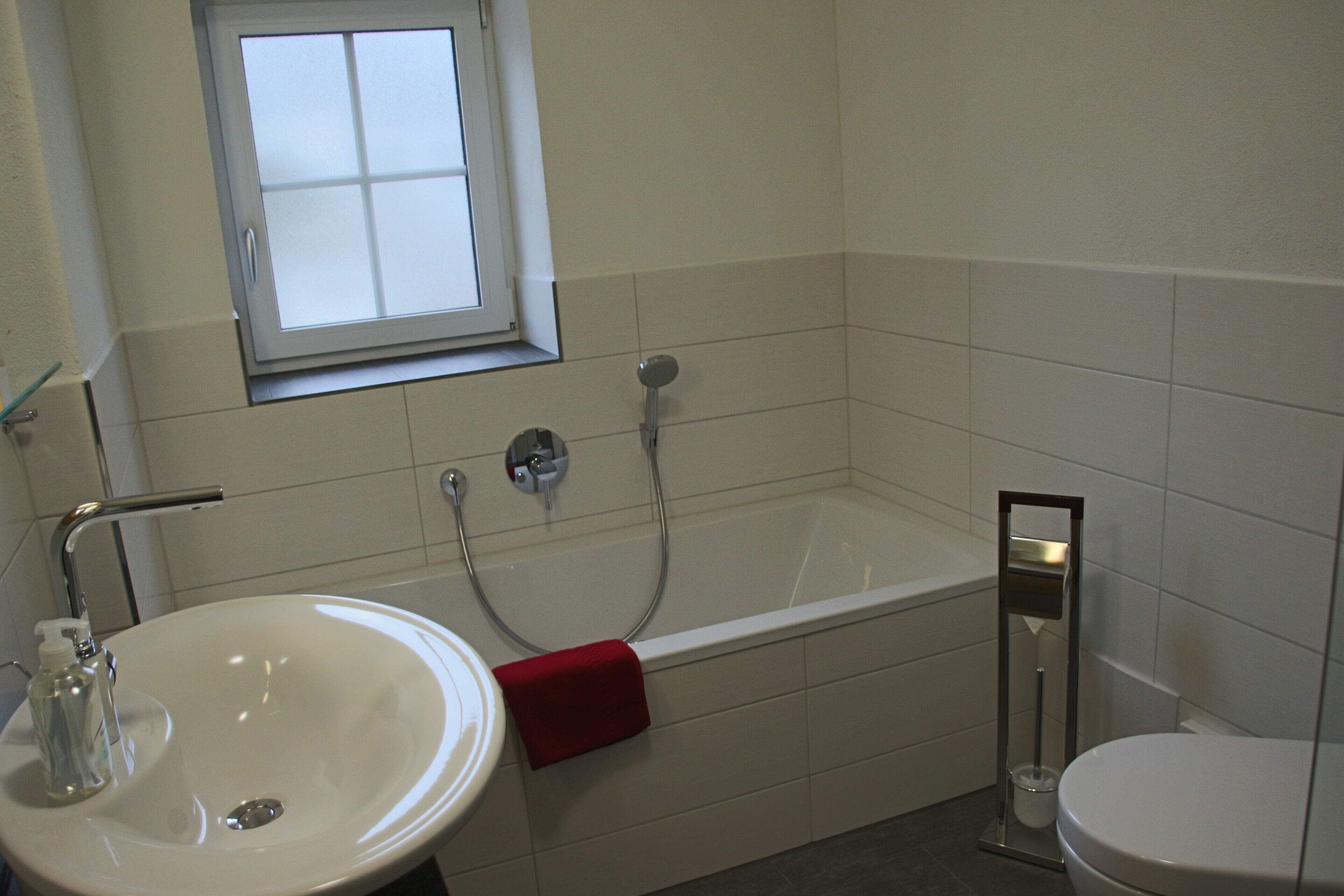 Un bagno con lavandino, vasca, finestra e water.
