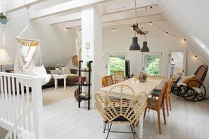 A spacious loft with a dining area, a living room, and a balcony with string lights. - Apartment 'Gode Stuv' with Private Terrace, Shared Garden and Wi-Fi (Högel)