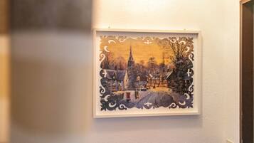 Ein gerahmtes Kunstwerk mit einer Stadtansicht an einer Wand.